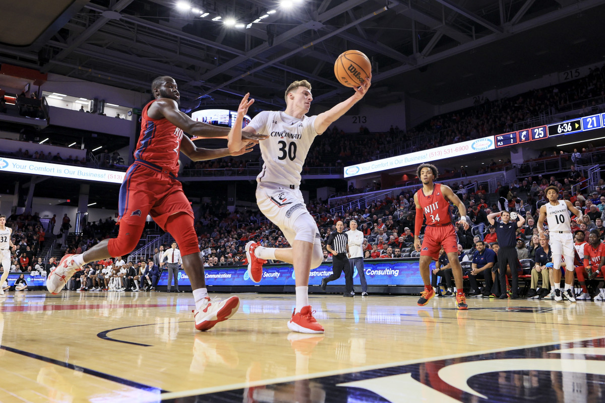 Nov 30, 2022; Cincinnati, Ohio, USA; Cincinnati Bearcats forward Viktor Lakhin (30) battles for the loose ball against N.J.I.T Highlanders forward Souleymane Diakite (21) in the first half at Fifth Third Arena. Mandatory Credit: Aaron Doster-USA TODAY Sports